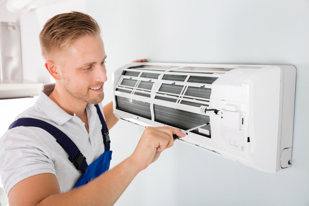 HVAC technician cleaning and repairing a ductless mini split AC in Johnstown, CO
