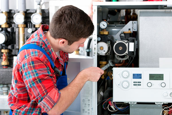 HVAC technician inspecting an indoor heating system in Johnstown, CO