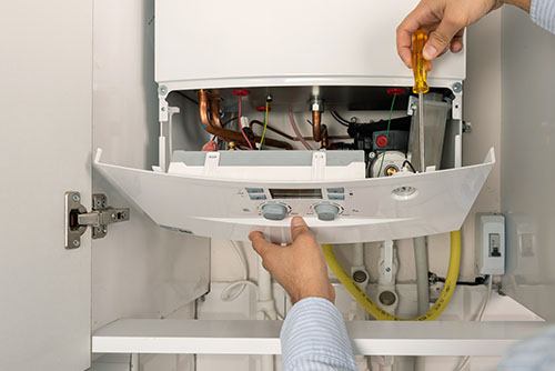 HVAC technician repairing an indoor boiler in Johnstown