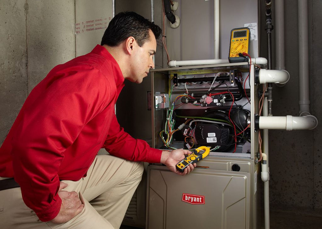 HVAC technician repairing an indoor furnace in Johnstown