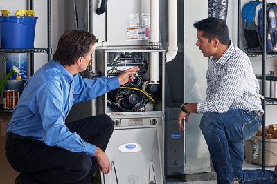 65df8c11f3e4c468cbd351a5_furnace repair vs replacement – Copy HVAC technician explaining furnace repair and maintenance to a homeowner in Johnstown, CO