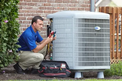 design-air-heating-and-air-conditioning-decatur-il-05 – Copy HVAC technician inspecting an outdoor air conditioning unit in Johnstown, CO