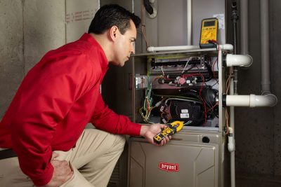 furnace repair Heating and air conditioning technician servicing an indoor furnace in Johnstown, CO